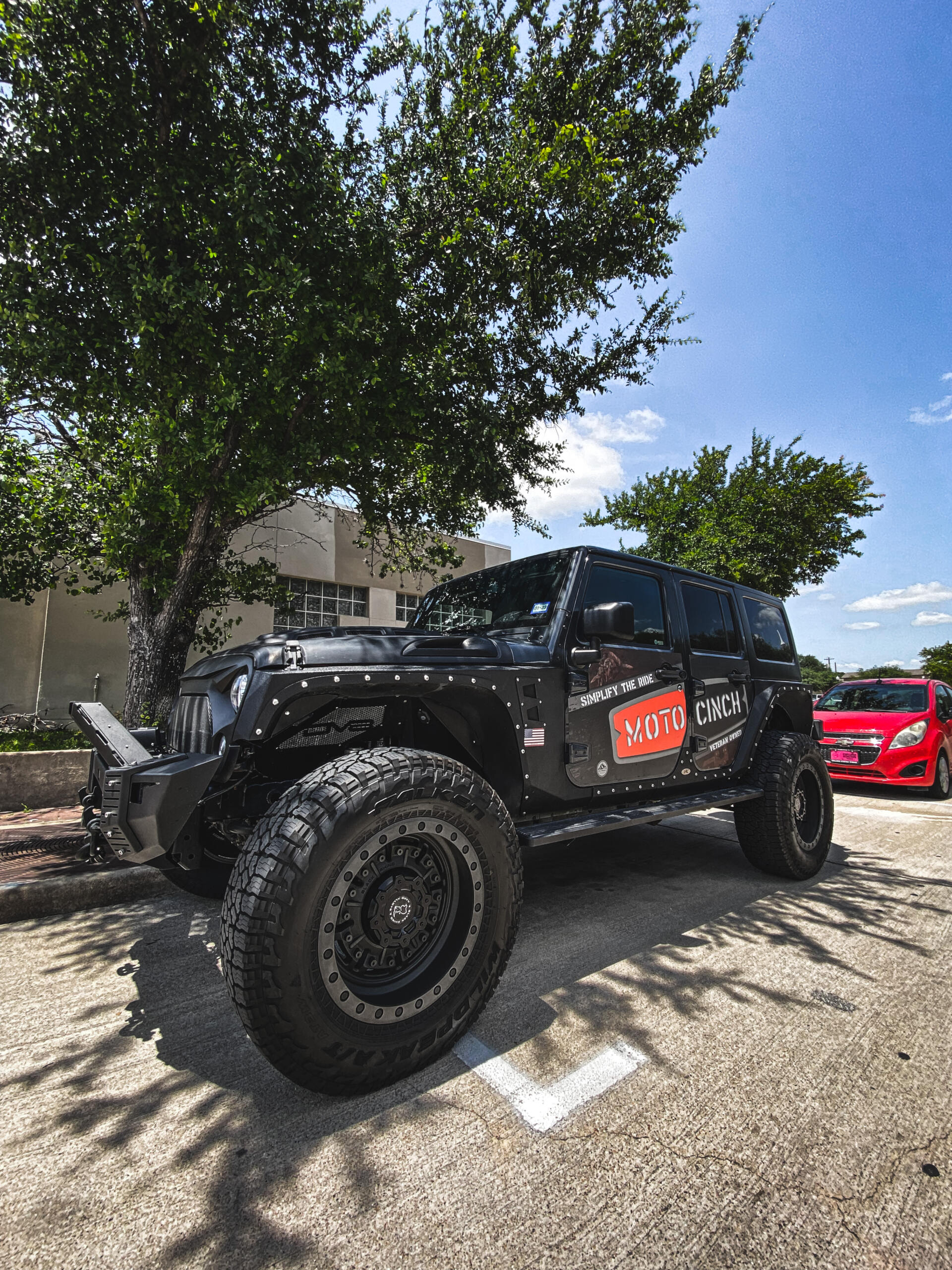 Moto cinch strapless tie downs for motorcycles uses the foot pegs to secure the bike